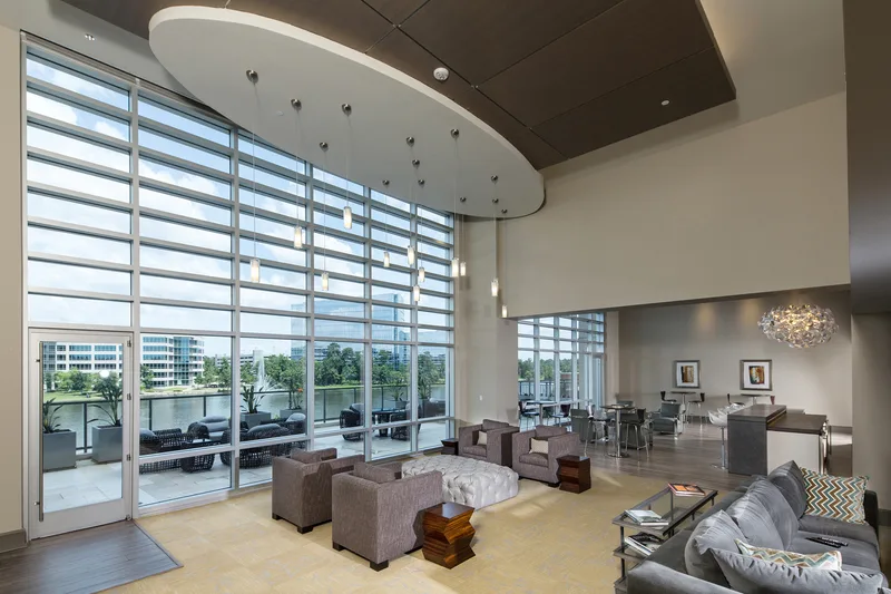 High-rise residential lounge with floor-to-ceiling curtain-wall glass and contemporary seating in Texas