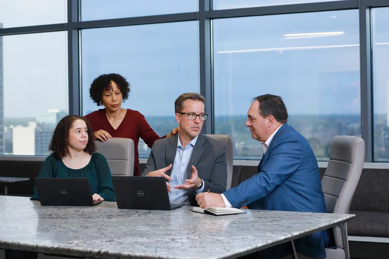 Corporate lifestyle conference room session professionals collaborating over Dell laptops in Houston, Texas