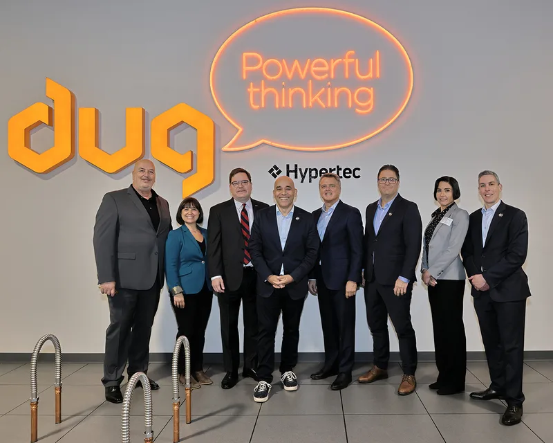 Group portrait at DUG SkyBox grand opening with Hypertec branding backdrop
